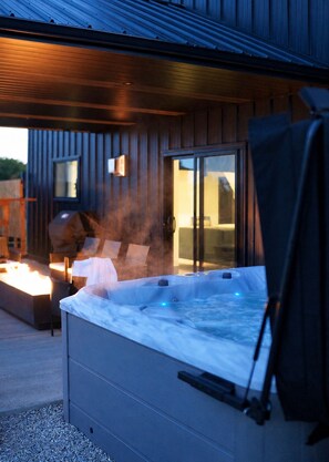 Un jacuzzi con tapa, un brasero y asientos exteriores.