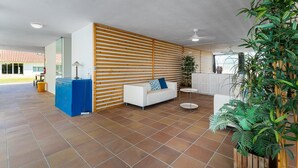 A spacious indoor area with a white sofa, a small round table, and a blue cabinet. - GuestReady - Quinta do Outeiro (Anadia)