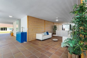 A spacious indoor area with a white sofa, a small round table, and a blue cabinet. - GuestReady - Quinta do Outeiro (Anadia)
