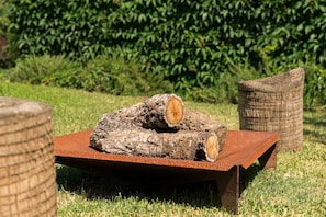 A rustic outdoor seating area with a wooden log and a metal table. - GuestReady - Quinta do Outeiro (Anadia)