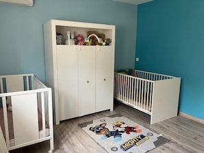 A room with two white cribs, a white wardrobe, and a blue wall. - Air-conditioned villa for 8 people with a swimming pool – La Crau (LA CRAU)
