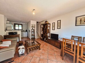 A living room with a sofa, coffee table, TV, and wooden shelves. - Air-conditioned triplex flat on the Port of Hyères (HYERES)