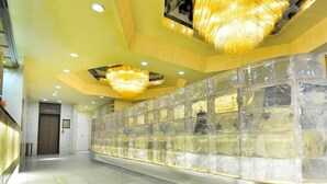 A hallway with a glass block wall, recessed lighting, and a chandelier. - Ikebukuro Grand Hotel (Tokyo)