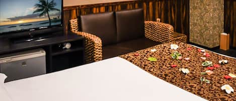 A hotel room with a bed, a TV, a desk, and a chair.