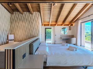 A bedroom with a large bed, a bedside table, a mirror, and a view of the outdoors. - Vacation home Aura by Interhome (Colico)