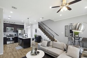A modern kitchen with dark cabinets, stainless steel appliances, and a central island. - Spacious 3BR, 2.5BA Home - Backyard Patio - Near Downtown Houston (Houston)