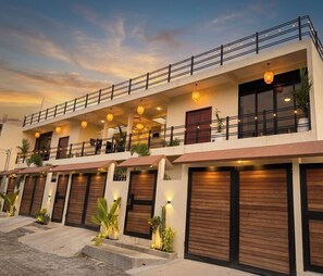 Un edificio de varios pisos con balcones, ventanas amplias y techo plano.