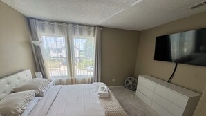 A bedroom with a bed, a TV, a dresser, and a window with curtains. - Spacious & Relaxing 3-bedroom house in Fishers (Fishers)