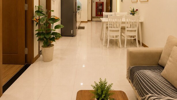 Una sala moderna con un sofá, una mesa de comedor con sillas, un refrigerador y una planta en maceta.