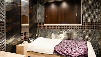 Une chambre d’hôtel moderne avec un grand lit, une coiffeuse avec un miroir et une grande fenêtre.