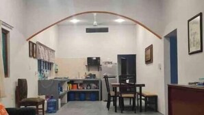 A spacious living area with a kitchen in the background, a dining table, and a sofa. - La Poza Country House, near the Costa Esmeralda-10 (Veracruz)