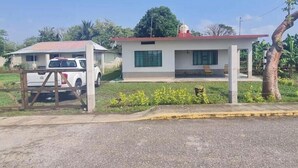 A two-story building with a flat roof, a small porch, and a vehicle parked in front. - La Poza Country House, near the Costa Esmeralda-10 (Veracruz)