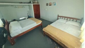 A room with two wooden beds, a small table, a fan, and a wardrobe. - La Poza Country House, near the Costa Esmeralda-10 (Veracruz)
