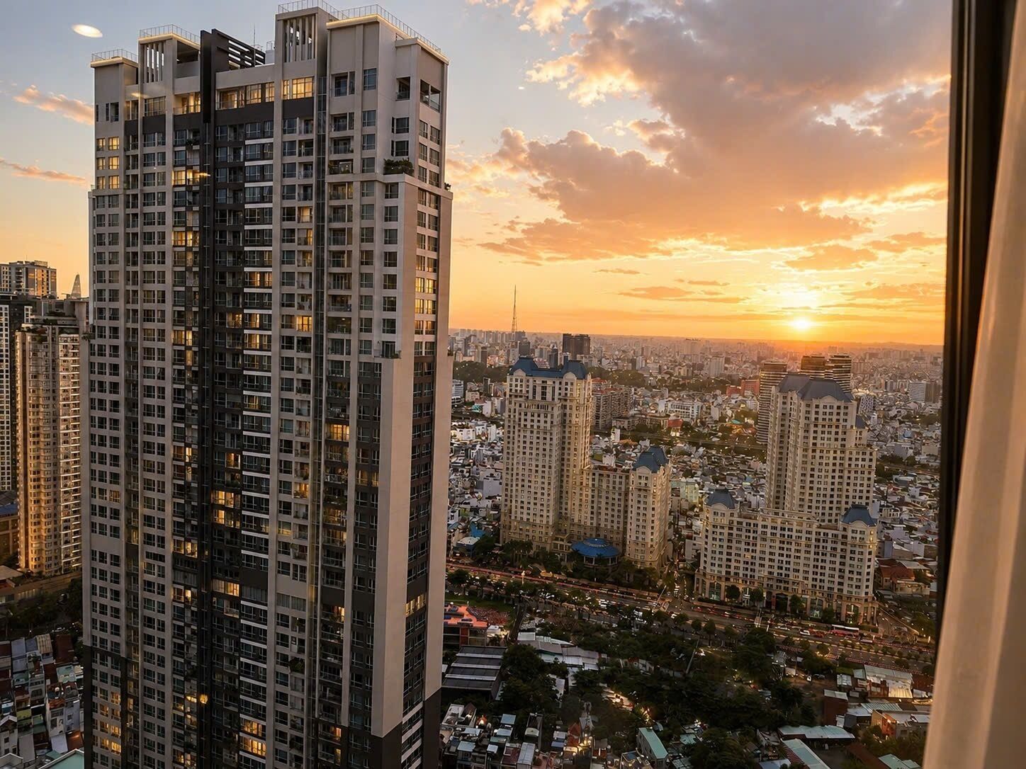 A high-rise building with multiple floors, surrounded by a cityscape during sunset.
