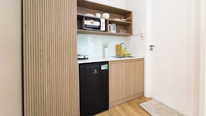 A compact kitchen with a dishwasher, microwave, and wooden cabinets. - Double Bedroom With Big Window District 1 (Thành phố Hồ Chí Minh)