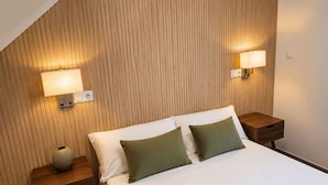 A hotel room with a bed, two bedside tables, and two wall-mounted lamps. - Madrid Pad With 2 Baths (Madrid)