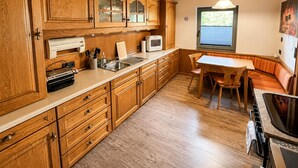 A kitchen with wooden cabinets, a microwave, and a stove.