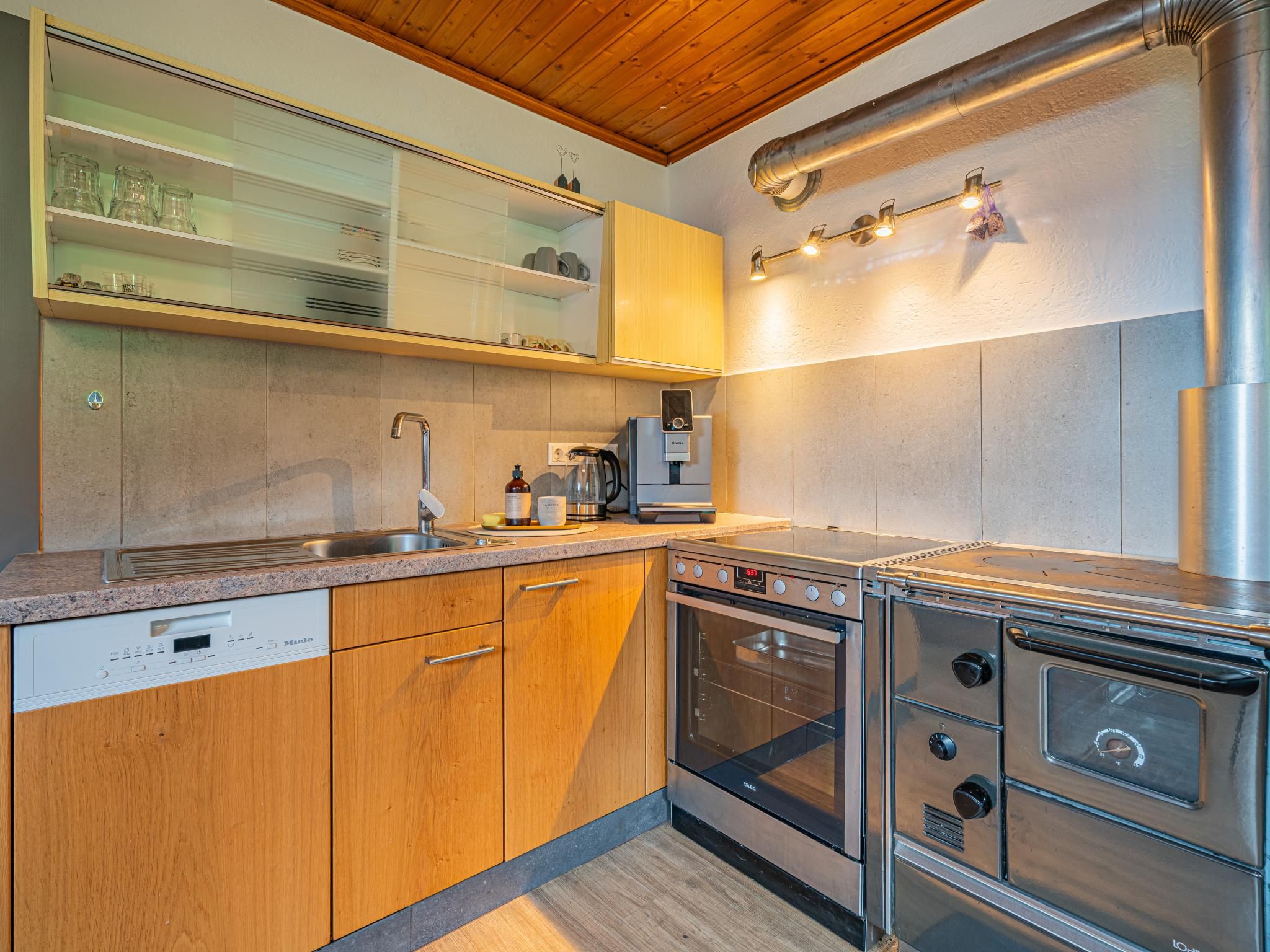 A modern kitchen with stainless steel appliances, wooden cabinets, and a built-in oven.
