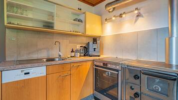 A modern kitchen with stainless steel appliances, wooden cabinets, and a built-in oven.