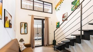 A modern interior with a staircase, a sofa, and artwork on the walls. - Elegant and Modern Loft in the Heart of Avola (Avola)