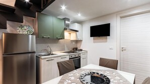 Een moderne keuken met een koelkast, fornuis, spoelbak en een eettafel met een decoratief bord.