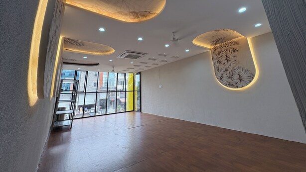 A spacious interior with a high ceiling, recessed lighting, and decorative wall panels. - The Hotel Phoenix Inn (Indore)