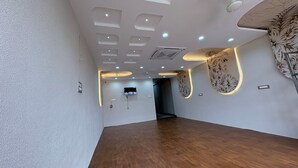 A modern hotel interior with a wooden floor, recessed lighting, and decorative wall panels. - The Hotel Phoenix Inn (Indore)