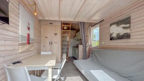 Ein kleines Zimmer mit Küchenzeile, Essbereich und einer Sitzecke.