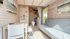 Ein gemütliches Blockhaus-Interieur mit Essbereich, einer Couch, einer Leiter und einem großen Fenster.