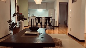 Un'area pranzo moderna con un tavolo in legno scuro, sedie nere e un lampadario.
