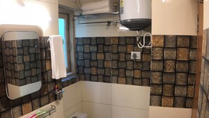 A compact bathroom with a sink, toilet, and a towel rack. - Backwoods B&B Mall Road Shimla (Shimla)