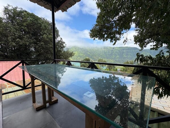 A glass table with a view of a lush landscape.