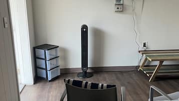 Ett hotellrum med en säng, en tv som är monterad på väggen, ett skrivbord och en stol.