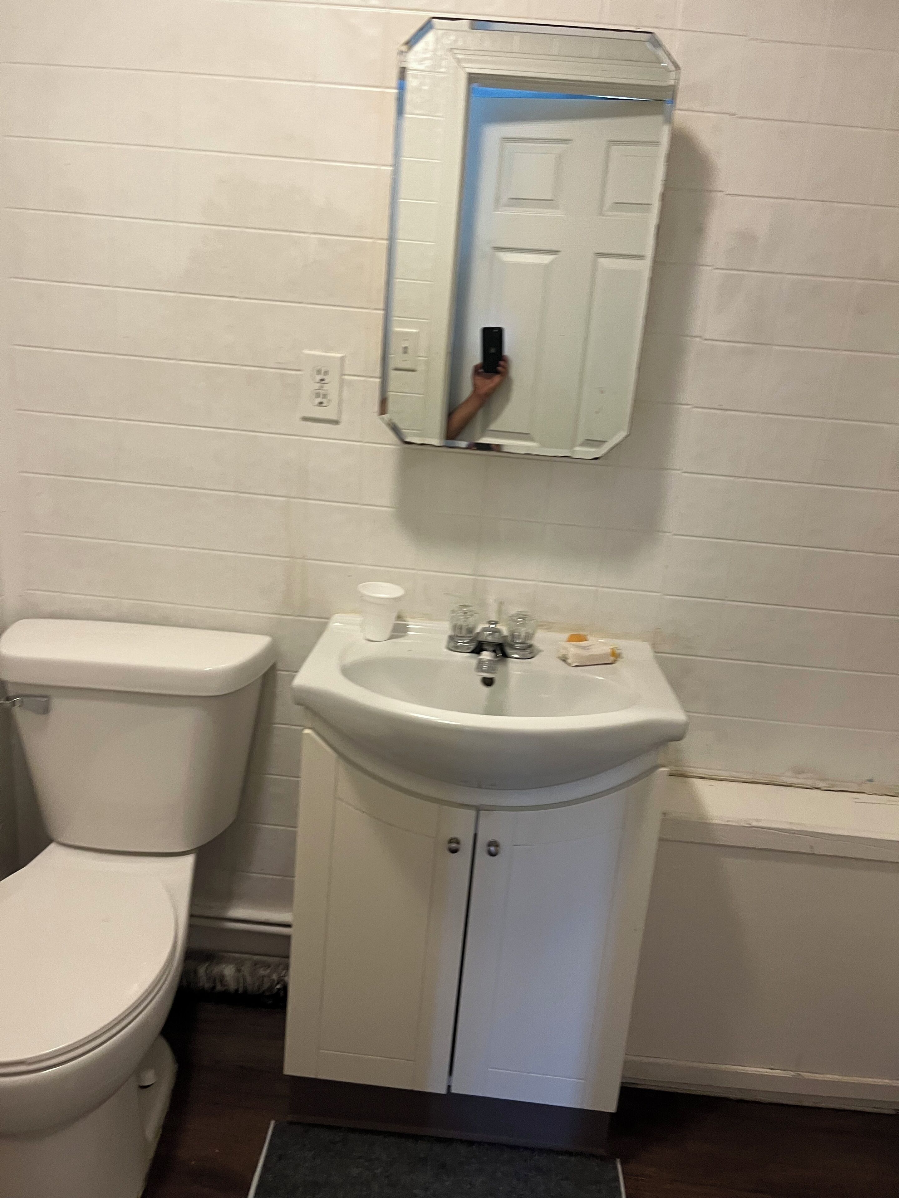 Un bagno con il water bianco, un lavandino e uno specchio.
