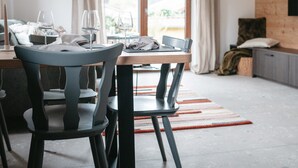 A modern dining area with a table, chairs, and a window with curtains.