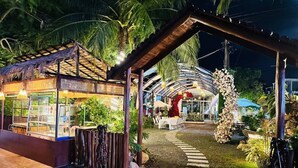 A restaurant with outdoor seating, a covered area, and a pathway leading to it. - Khemra Boutique in Kampot (Kampot)