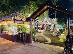 A restaurant with outdoor seating, a covered area, and a pathway leading to it. - Khemra Boutique in Kampot (Kampot)