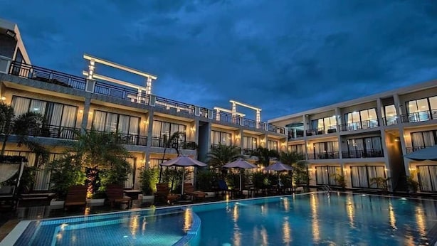 A hotel with a swimming pool, multiple balconies, and outdoor seating areas. - Khemra Boutique in Kampot (Kampot)