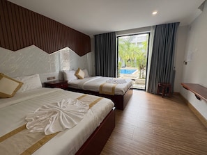 A hotel room with two beds, a wooden floor, a view of a swimming pool, and a balcony. - Khemra Boutique in Kampot (Kampot)
