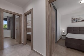 A modern bedroom with a large bed, a nightstand, and a painting on the wall. - Zadar Family Residence (Zadar)