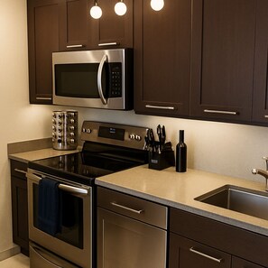 A modern kitchen with stainless steel appliances, a built-in oven, a microwave, and a sink.