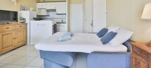 A hotel room with a bed, a TV, a kitchen area, and a bar. - Ancora 6  Studio avec vue sur la baie des Sables-d’Olonne (Les Sables-d´Olonne)