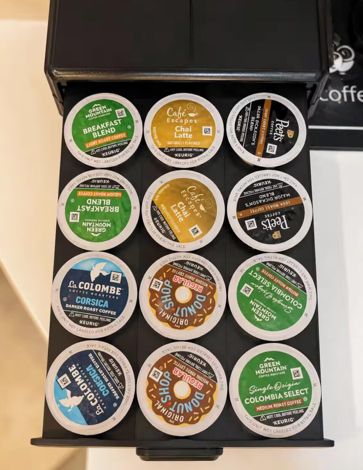 A coffee machine with various coffee pods arranged in rows.