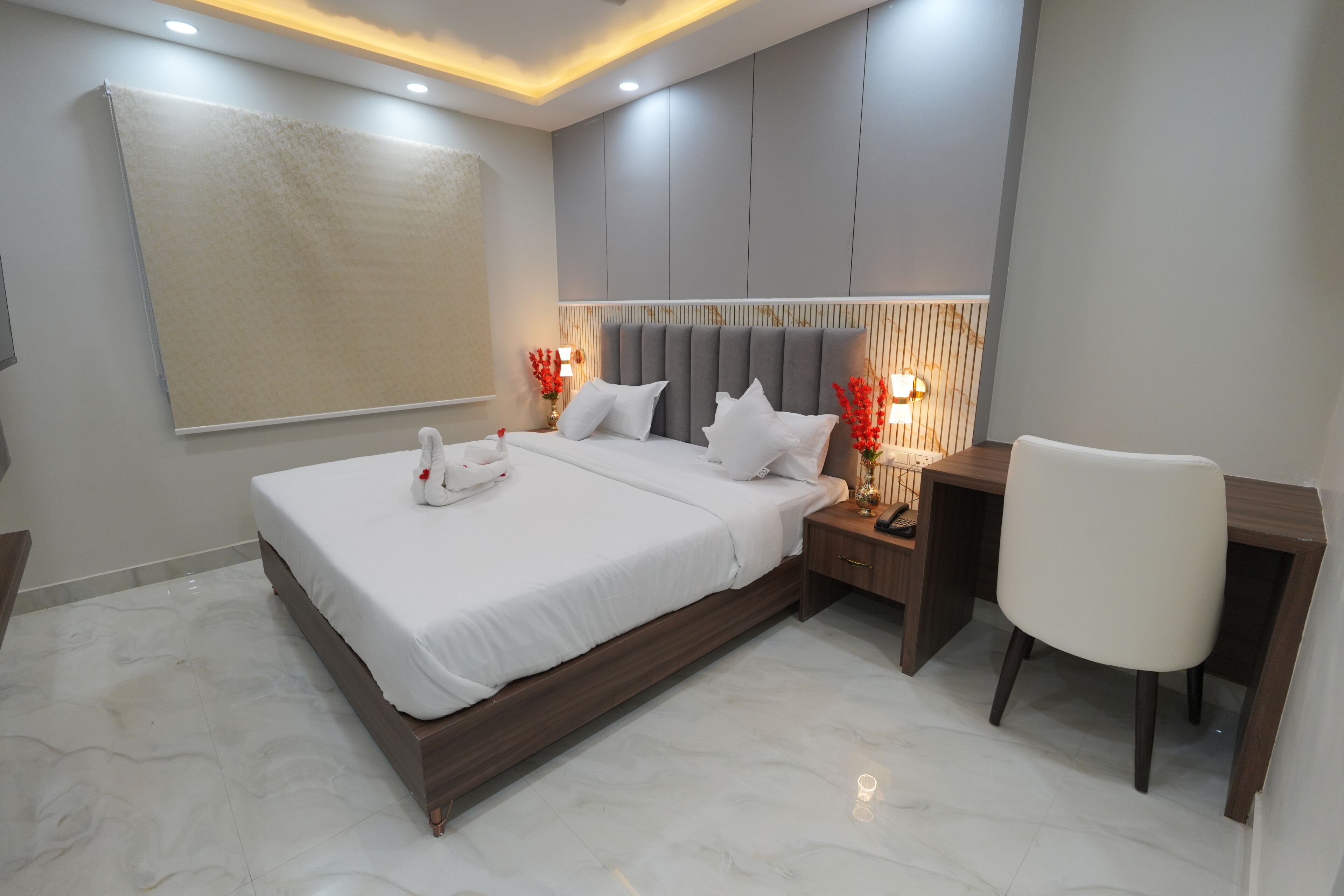 Quarto de hotel moderno com uma cama grande, uma mesa e uma cadeira.