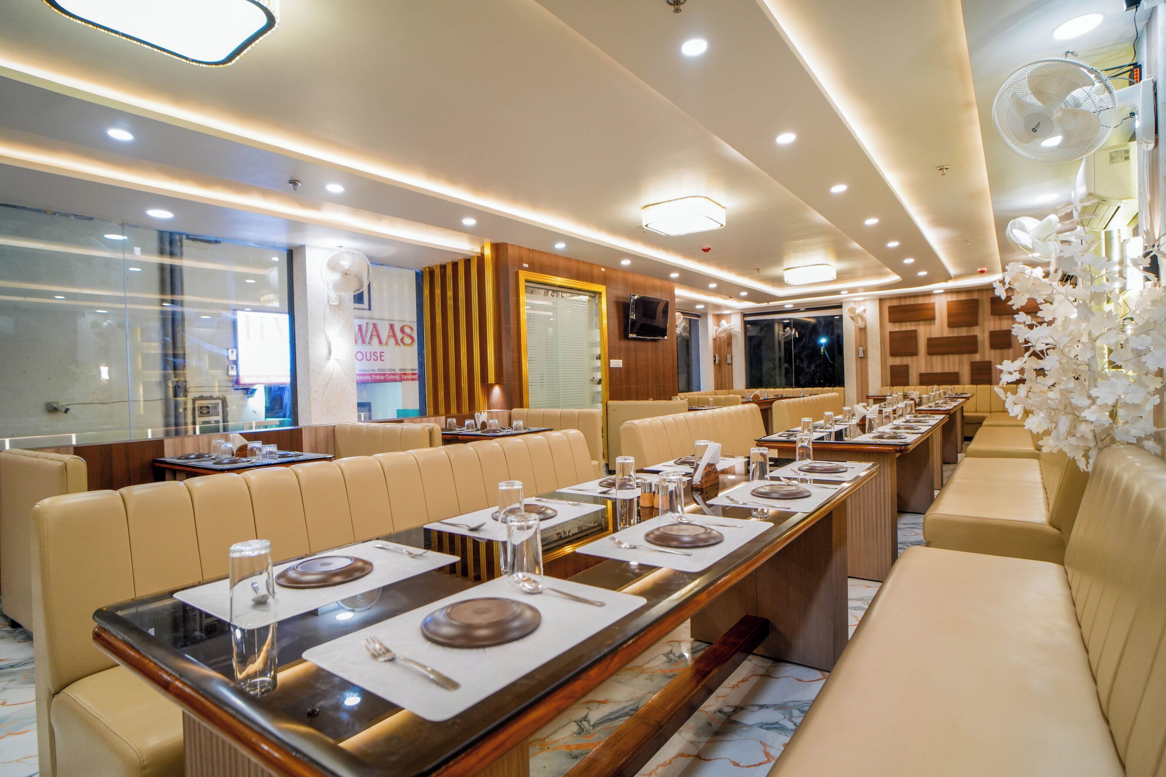 A restaurant with long tables, cushioned booths, and a modern interior design.