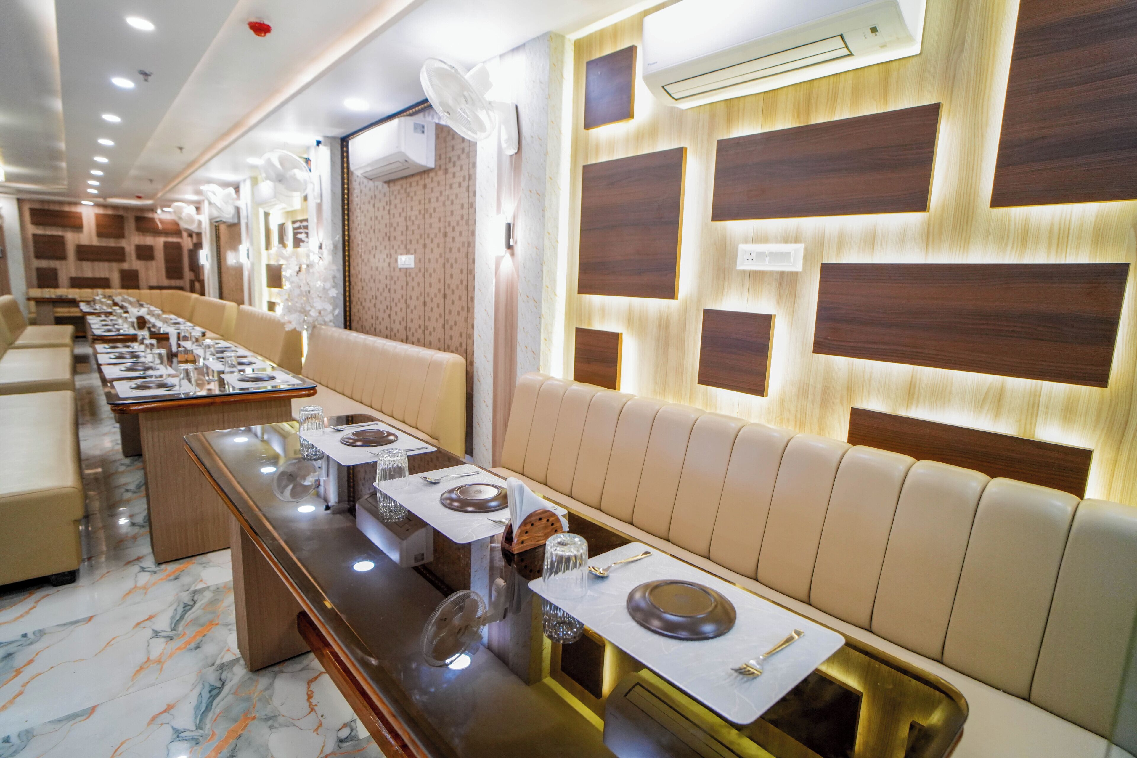 A restaurant with long tables, cushioned seating, and a modern design.