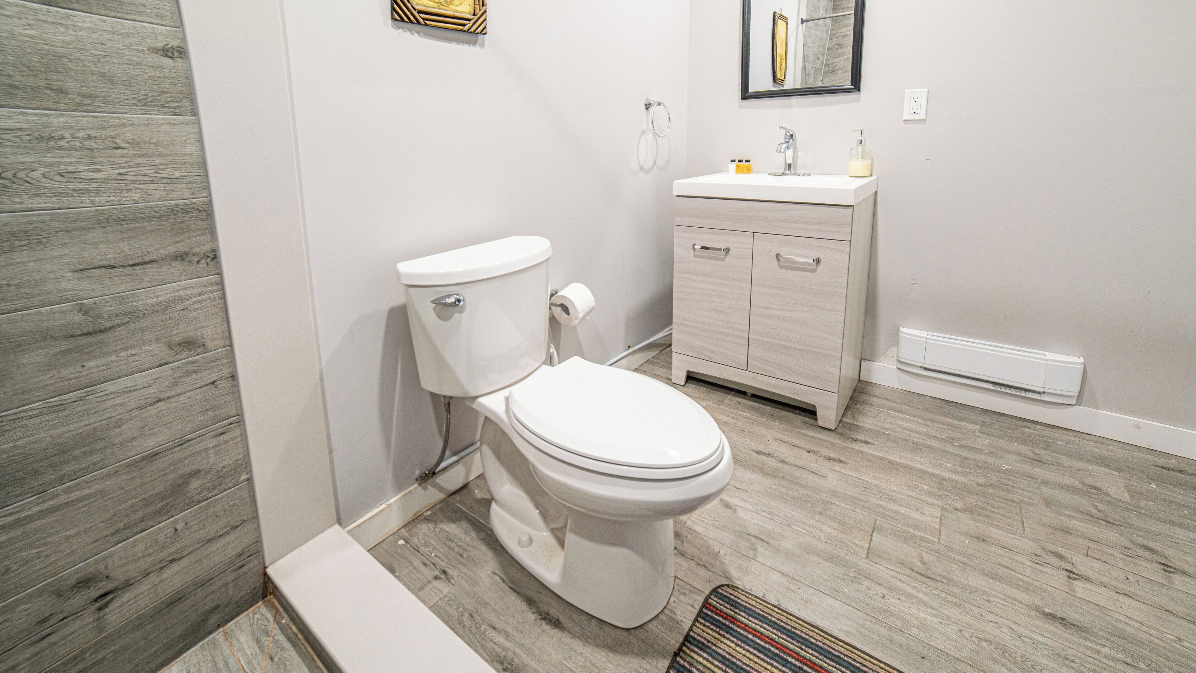 Une salle de bain avec des toilettes, un lavabo et un miroir.