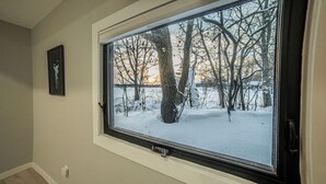 Une pièce dotée d’une grande fenêtre, d’une porte et d’un interrupteur fixé au mur.