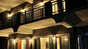A two-story building with a balcony, a hot tub, and a staircase leading to the entrance. - Rustic Pines (Solan)