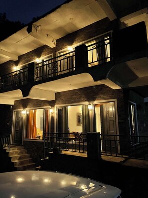 A two-story building with a balcony, a hot tub, and a staircase leading to the entrance. - Rustic Pines (Solan)